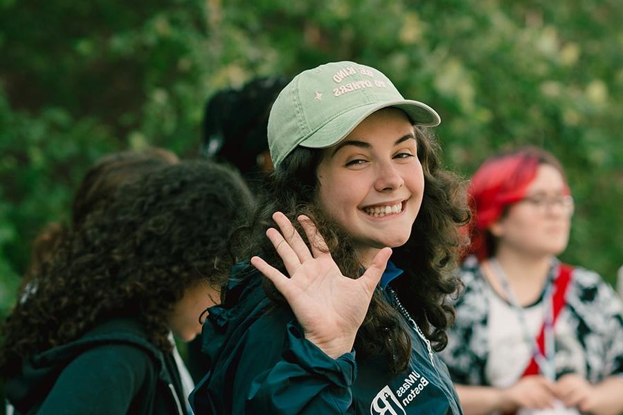 female student with cap looks back and waves